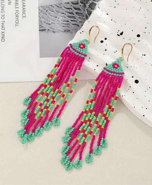 Colorful beaded earrings on a white surface with a blurred background